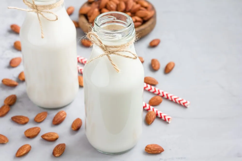 Almond,Milk,In,Glass,Bottles,With,Almonds,On,Background,,Horizontal,
